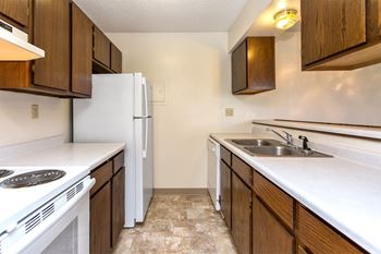 a kitchen with white appliances and wooden cabinets